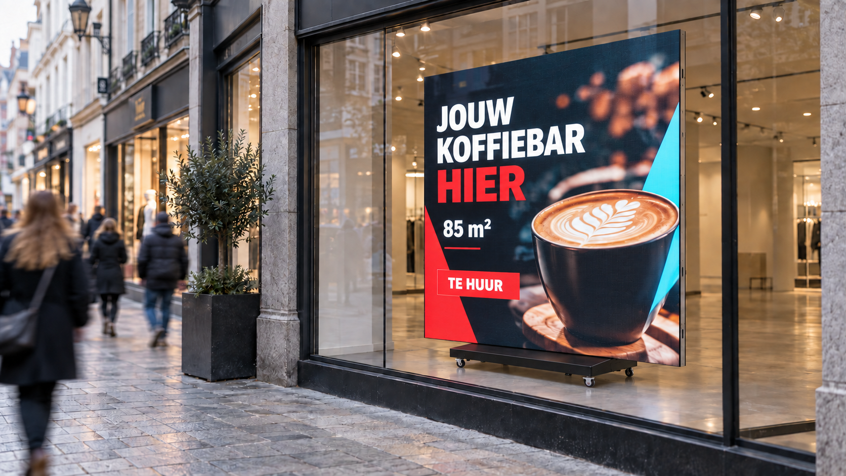 Digitaal scherm achter de etalageruit van een handelspand in een winkelstraat, met afwisselend een te-huurpresentatie en een commerciële campagne.